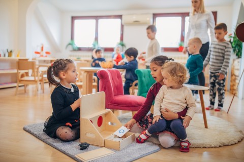 In Kita spielende Kinder mit Erzieherin